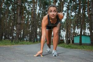 Young woman running outdoors in a city park photo