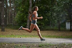 Young woman running outdoors in a city park photo