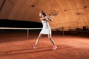 young sportswoman playing tennis photo