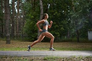 Young woman running outdoors in a city park photo