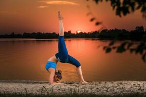 yoga a puesta de sol en el playa. foto