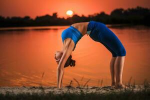 yoga a puesta de sol en el playa. foto