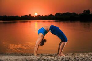 yoga a puesta de sol en el playa. foto