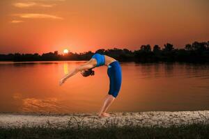 yoga a puesta de sol en el playa. foto