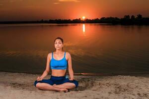 yoga a puesta de sol en el playa. foto