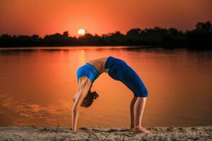 yoga a puesta de sol en el playa. foto