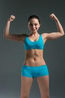 young athletic girl shows muscles photo