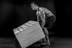 joven muscular hombre voltear caja foto