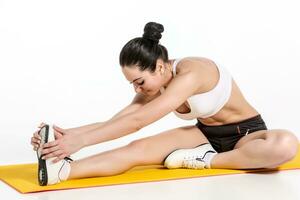 attractive woman doing exercises. Brunette fit body on yoga mat photo