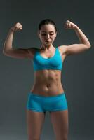 young athletic girl shows muscles photo