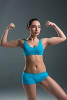 young athletic girl shows muscles photo