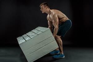 Young Muscular man flipping box photo