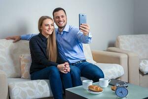 Beautiful young man and woman doing selfie with telephone camera photo