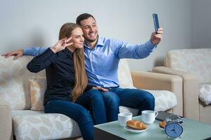 Beautiful young man and woman doing selfie with telephone camera photo