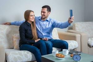 Beautiful young man and woman doing selfie with telephone camera photo