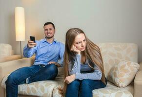Portrait of couple sitting on sofa watching television. photo