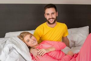 joven encantador Pareja acostado y tener divertido en un cama foto