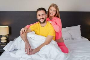 Young lovely couple have fun in a bed photo