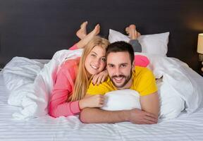 Young lovely couple lying and have fun in a bed photo