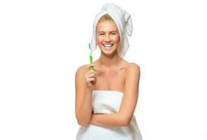 joven mujer en toalla con cepillo de dientes sonriente foto