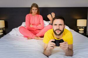 Young couple having playing videogames in bed photo