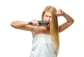 Pretty woman in towel singing using comb photo