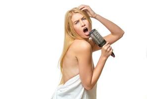 Pretty woman in towel singing using comb photo