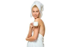 Young woman in towel drinks from a cup photo