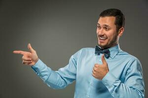 Smiling man pointing to something with an index finger photo