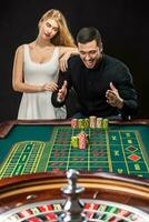 Couple playing roulette wins at the casino. photo