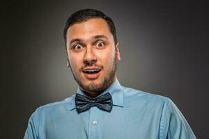 Portrait young man in blue shirt, looking with amazement photo