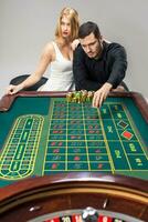 hombres con mujer jugando ruleta a el casino. foto