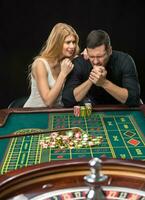 Men with women playing roulette at the casino. photo