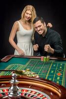 Young couple celebrating win at roulette table in casino. photo