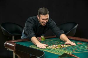 joven hermoso hombre jugando ruleta gana a el casino foto