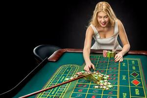 Young pretty women playing roulette wins at the casino photo