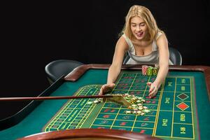 Young pretty women playing roulette wins at the casino photo