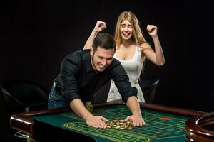 Young couple celebrating win at roulette table in casino. photo