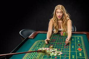 Young pretty women playing roulette wins at the casino photo