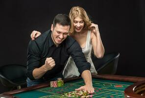 Young couple celebrating win at roulette table in casino. photo