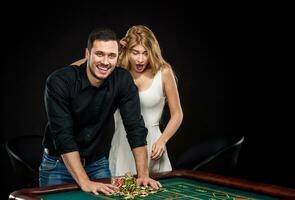 Young couple celebrating win at roulette table in casino. photo