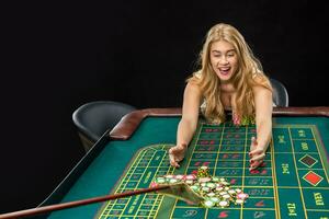 Young pretty women playing roulette wins at the casino photo