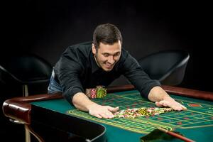 joven hermoso hombre jugando ruleta gana a el casino foto