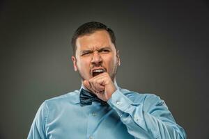 Young man yawns, covering her mouth. Closeup photo