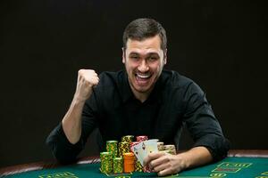 Happy poker player winning and holding a pair of aces photo