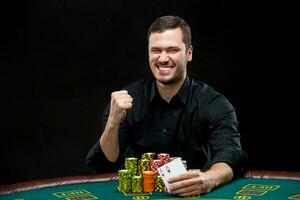 Happy poker player winning and holding a pair of aces photo