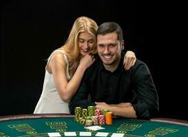 Young couple playing poker have a good time in casino photo