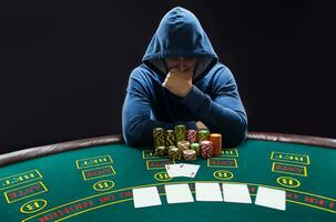 Portrait of a professional poker player sitting at pokers table photo