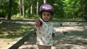 retrato de un pequeño niña en un protector casco y protector ropa. video