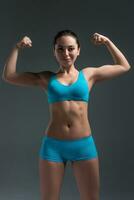 young athletic girl shows muscles photo